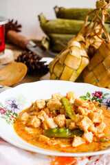 Lebaran Menu, Ketupat, Lontong accompanied by side dishes of Vegetable Soup, Tofu, Rambak and Potatoes with red syrup drink, a typical dish during Eid al-Fitr in Indonesia