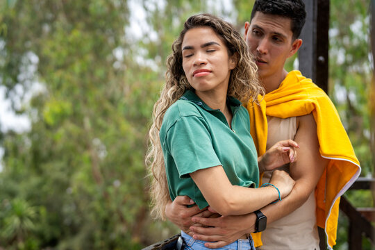 Young couple arguing and distancing while embracing in park