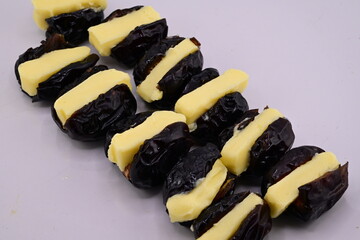 Capture the essence of indulgence with this close-up shot of ajwa dates, each crowned with a swirl of rich, golden butter.