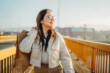 Obraz premium Young caucasian woman go home with full shopping bags after shopping 