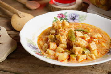 Close up of tofu rambak vegetables, potatoes with red syrup drink. Tofu vegetables are a side dish for Ketupat, a typical dish during Eid al-Fitr in Indonesia.