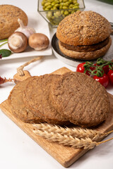 Round vegetarian patties or burgers made from grains, vital wheat gluten food, uncooked and grilled