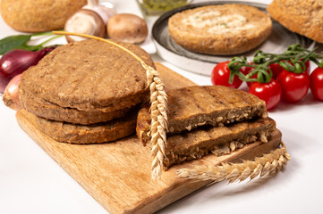 Round vegetarian patties or burgers made from grains, vital wheat gluten food, uncooked and grilled