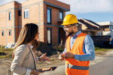 Female supervisor and architect having serious conversation and fight at construction site.