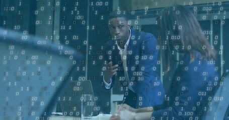 Discussing strategy, diverse professionals in business meeting with binary code overlay - Powered by Adobe