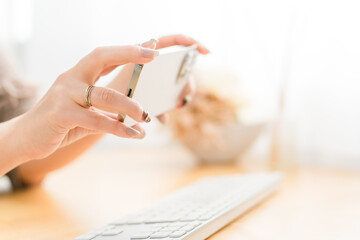 スマホ・スマートフォンのカメラを使って写真を撮るネイルをした女性
