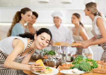 Girl after class at culinary master class completes work by decorating finished dish. Food serving option