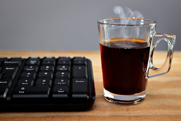 Xícara de café com teclado de computador preto