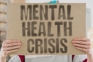 "Mental health crisis" on worn cardboard. Highlights widespread issues with psychological well-being. SUFFERING. ANXIETY. DEPRESSION. TRAUMA. STRESS. SUPPORT. TREATMENT