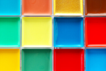 Bright face paint palette as background, top view