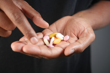 Hands holding colorful pills for health or dietary supplement