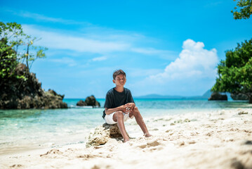 Obraz premium Boy on the beach with beautiful natural scenery background