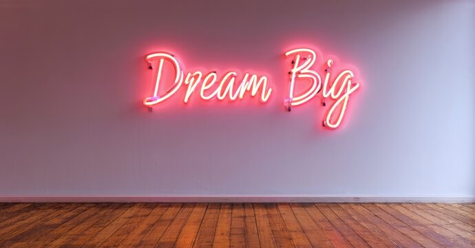 Naklejki Neon sign dream big warm coral bright cyan mounted minimalist studio wall casting reflections glossy wooden floor sleek workspace