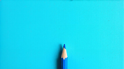 a blue pencil against a bright blue background