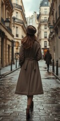 Naklejka premium Woman in Stylish Brown Coat Walking Down Historic European Street