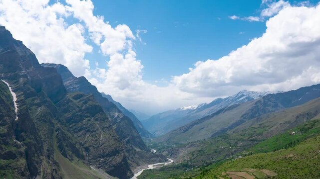 4K Zoom in timelapse of clouds moving over beautiful mountain landscape as seen from Marbal village, Lahaul, India. River flowing through mountains during summer season. Nature background.