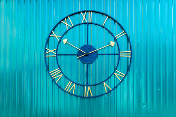 Large Roman numeral clock on blue wall