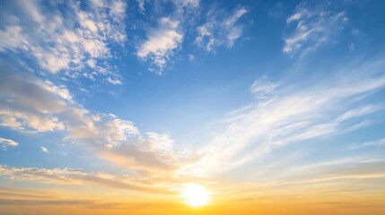 Obraz premium Scenic view of clouds in the sky at sunset with warm golden and orange hues, creating a peaceful and dramatic atmosphere. Nature, weather, and evening sky landscape concept.