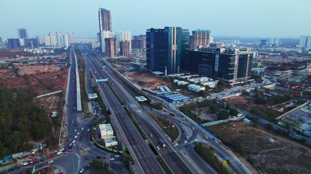 Glass facade buildings with Financial District, OOR and vehicles at Nanakramguda, Hyderabad, Telangana, india. day time, semi orbit, drone shot, 4k.