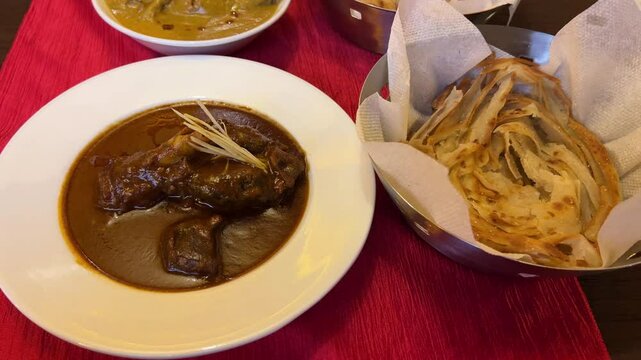 Assortment of mutton nihari, chicken kosha and naan served to guests at wedding.