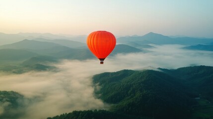 Fototapeta premium Orange Hot Air Balloon Floating Over Misty Mountain Landscape