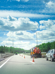 Naklejka premium Group of workers are on the side of the road, fixing a road