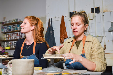 Female potters working with clay in pottery workshop