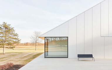 Fototapeta premium Modern white building exterior with clear glass windows and minimalist design on a sunny day