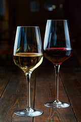 Two glasses of wine on a wooden background.