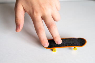 children's hands playing with a toy fingerboard, developing fine motor skills, selective focus
