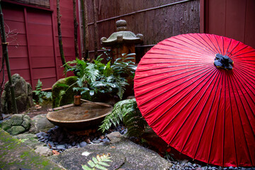 A Japanese umbrella within a secluded japanese garden within a home.