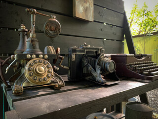 Telephone, camera and old rusty antique typewriter on the table