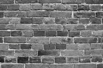 Wall background of dark grey bricks. Grey brick wall background. Dark grey wall closeup.