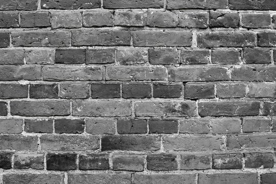 Fototapeta Wall background of dark grey bricks. Grey brick wall background. Dark grey wall closeup.