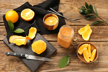 Composition with glass of healthy orange smoothie and ingredients on wooden table