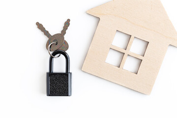 A mock-up of a wooden house and a lock with keys stand out on a white background. The concept of...