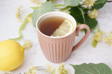 Cup of linden tea with lemon on white background