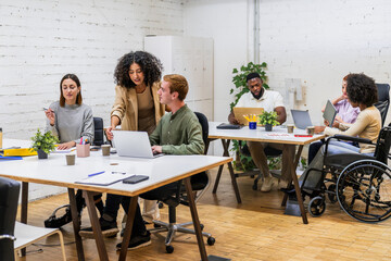 Diverse businesspeople collaborating in modern coworking space