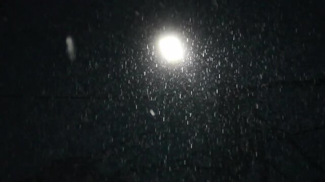 Heavy rain and street light in dark background. Torrential rain in night with light lamp. Rain falls with light. Raindrops drip in rainy night. Rain water drops in heavy rain with dark background.