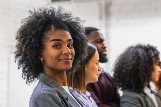 Young african american businesswoman smiling with colleagues in coworking space