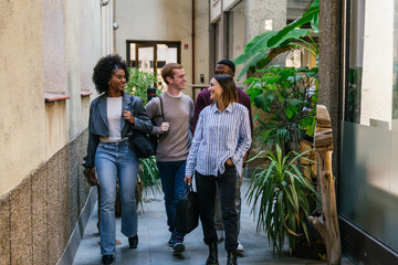Fototapeta premium Young professionals walking and talking in modern coworking space