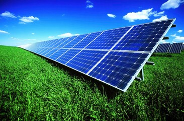Solar panels on a grassy field under a vibrant blue sky