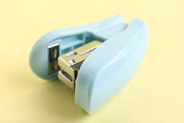 Blue stapler on yellow background