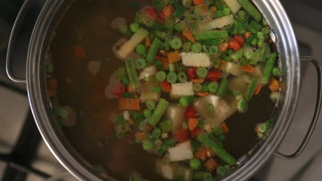 Cooking vegetable soup with many frash ingredients left to boil on the hob