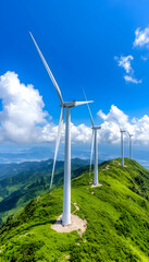 Majestic wind turbines atop verdant mountain ridge under a vibrant blue sky