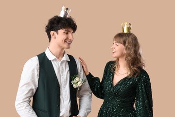 Happy prom couple with crowns on beige background © Pixel-Shot