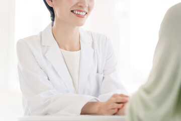 白衣を着た女性が患者と話している。