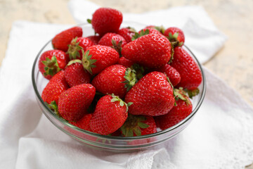 Glass bowl with sweet fresh strawberries on grunge background