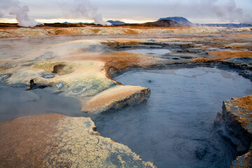 Steaming volcanic fumarole, boiling mud pits and mineral stained earth at Namaskard Geothermal Area in Iceland