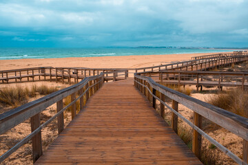 Obraz premium Ocean Beach in Portugal with Wooden Boardwalks. Scenic wooden pathways stretch along the coastline, inviting peaceful walks and endless exploration
